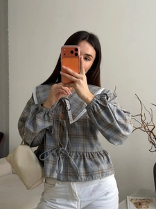 Detail of grey plaid cropped shirt with lace Peter Pan collar and bow-tie closures
