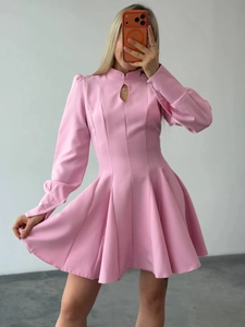Close-up of pink long sleeve dress with keyhole cutout and pleated A-line skirt detail