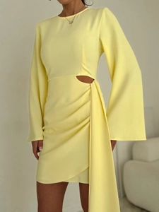 Détail de la robe mini jaune clair avec découpe à la taille et drapé plissé élégant