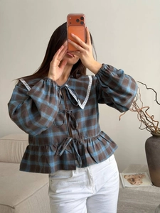 Detailed view of plaid shirt with lace Peter Pan collar and front tie-up bows