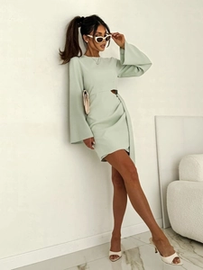Détail de robe vert menthe à manches longues avec découpe à la taille et ruban élégant