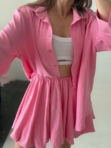 Détail de chemise rose à manches longues et short plissé à taille haute avec texture froissée