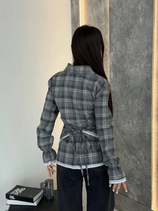 Detail view of plaid shirt with lace cuffs and adjustable lace-up back design