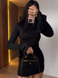 Detail of elegant bell sleeves with tiered ruffles on a black slim fit dress