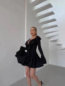 Detailansicht der V-Ausschnitt Rüschen und Schnürung an einem schwarzen Mini-Kleid