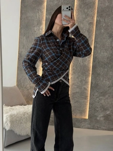 Detail view of plaid shirt with wrap front design and white lace trim on sleeves