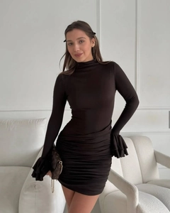 Detail view of ruched bodycon dress showing high neck and elegant flared ruffle cuffs