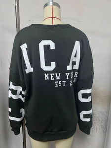Detail of black sweatshirt featuring white New York and Chicago typography and ribbed cuffs