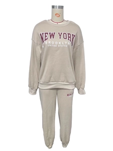 Detail showing plush fabric and New York Brooklyn print on beige leisure tracksuit