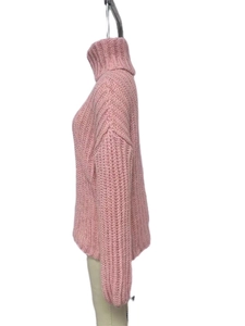 Detailed close-up of pink turtleneck sweater showing chunky knit texture and soft fabric