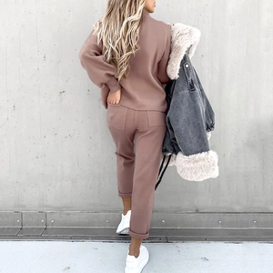 Rear view of a stylish dusty pink two-piece knit tracksuit set for women in outdoor setting