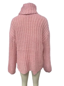 Detail of light pink chunky knit turtleneck sweater showing back view and textured pattern