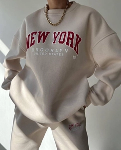 Close-up of New York Brooklyn red embossed lettering on beige fleece tracksuit set