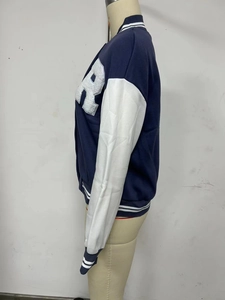 Detail view of navy blue varsity jacket with white towel embroidery and striped ribbing
