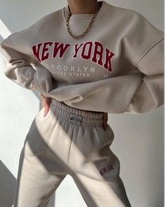 Close-up of New York print on beige fleece sweatshirt and pants tracksuit set
