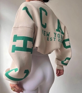 Detail of New York EST 20 vintage print on the back of beige oversized hoodie