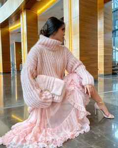 Close-up of pink oversized knit sweater with lantern sleeves and matching pleated skirt