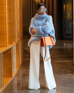 Detail of light blue mohair turtleneck sweater paired with white wide-leg trousers