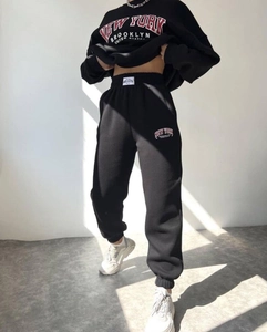 Detail of black tracksuit with red outlined New York Brooklyn print and ribbed cuffs