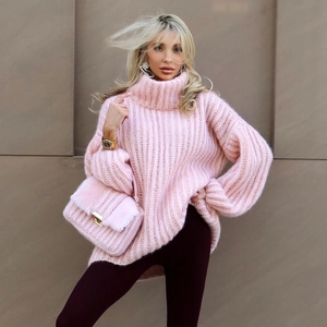 Detail of pink turtleneck knit sweater with chunky ribbed texture and puffy sleeves