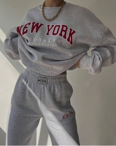 Detail view of grey two-piece tracksuit with New York print and brand label on waist