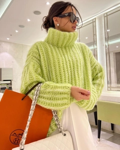 Detail of chunky knit emerald green turtleneck sweater with textured vertical stripes