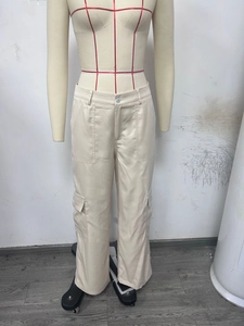 Detail of cargo pants showing high waist cut, side flap pockets, and cotton fabric texture