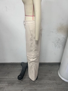 Detail view of khaki cargo pants featuring large side flap pockets and twill fabric