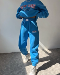Detail view of Klein blue fleece tracksuit featuring vintage red letter prints on cotton fabric