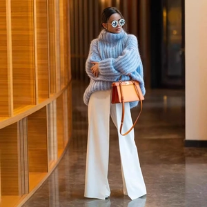 Light blue turtleneck chunky knit sweater with puff sleeves and orange handbag