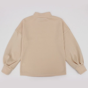 Detail view of the mock neck and drop shoulder design on a beige fleece sweatshirt