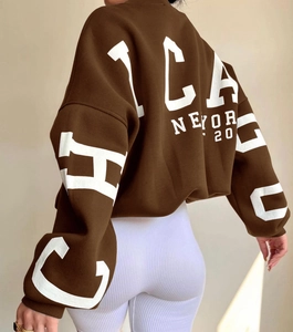 Detail view of oversized dark brown sweatshirt with Chicago white graphic print on the back