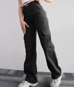Detail view of black high-waisted cargo pants with large side utility pockets and cotton fabric