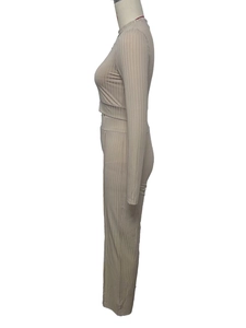 Detail view of beige ribbed fabric texture on women's long sleeve top and pants set