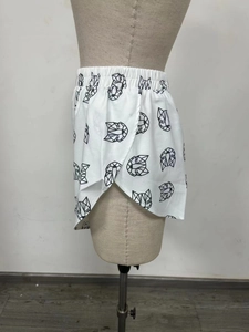 Detail der weißen Freizeitshorts mit geometrischem Tierdruck und Seitenschlitz