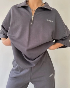 Detail view of MAI STUDIOS CO. logo on dark grey short sleeve sweatshirt and shorts set