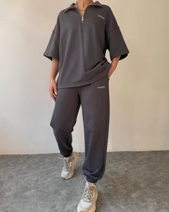 Detail view of charcoal gray half-zip tracksuit with MAI STUDIOS print on fabric