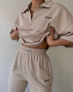 Detail of beige two-piece lounge set with half-zip sweatshirt and drawstring sweatpants