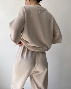 Detail view of the logo label on the back of this beige loungewear sweatshirt set