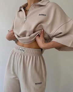 Detail of beige two-piece lounge set featuring half-zip top and drawstring sweatpants