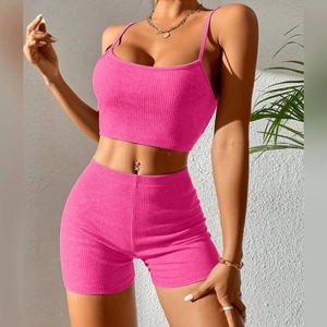 Detail of rose pink ribbed knit two-piece set featuring camisole crop top and high waist shorts