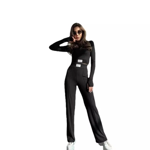 Women's black ribbed knit two-piece set featuring long sleeve crop top and wide leg pants