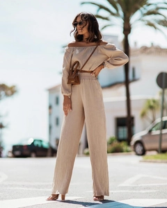 Detail of off-shoulder long sleeve top and wide leg pants in beige textured fabric