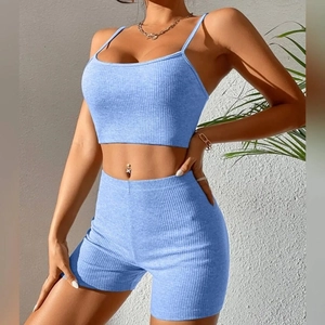 Close-up of light blue ribbed knit texture on crop top and high waist shorts