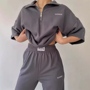 Dark grey two-piece tracksuit set with loose half-zip sweatshirt and drawstring joggers