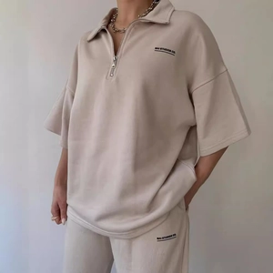 Casual beige two-piece set featuring short sleeve half-zip sweatshirt and matching trousers