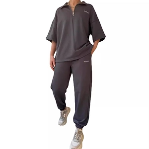 Men's dark grey two-piece tracksuit featuring a half-zip short sleeve hoodie and joggers