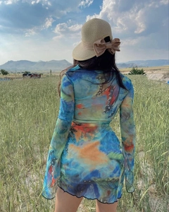 Outdoor shot of a long-sleeved dress with vibrant butterfly prints and a straw hat