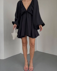 Detail eines eleganten schwarzen Minikleids mit V-Ausschnitt, Puffärmeln und Strukturstoff