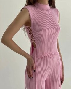 Detail of pink knit two-piece set featuring a high-neck top with chic side lace-up cutouts